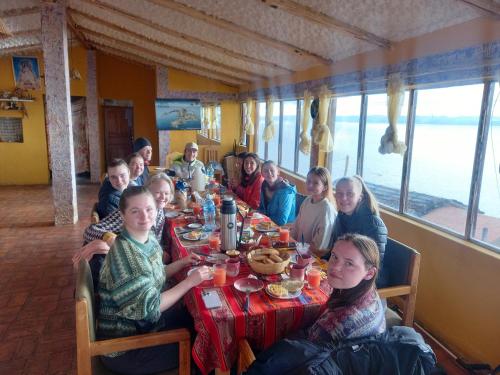 eine Gruppe von Menschen, die an einem Tisch in einem Restaurant sitzen in der Unterkunft Refugio Ecologico Kalluchi in Comunidad Yumani