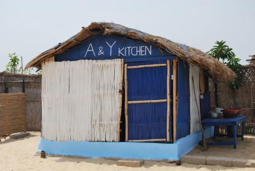 a small blue and white building with a thatch roof at A&Y Wild Camp Ghana in Keta