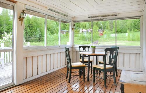 GryttvedにあるStunning Home In Skillingsforsのテーブルと椅子が置かれた網戸付きのポーチ