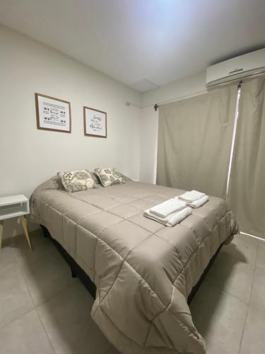 Fama Suite YB في La Rinconada: غرفة نوم بسرير كبير عليها منشفتين