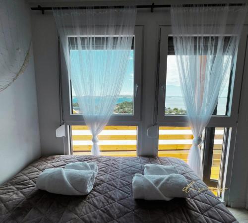 a bedroom with a bed and two large windows at d-view Premium Mobile Home - panoramic seaview - 150 m from beach, free parking in Drage