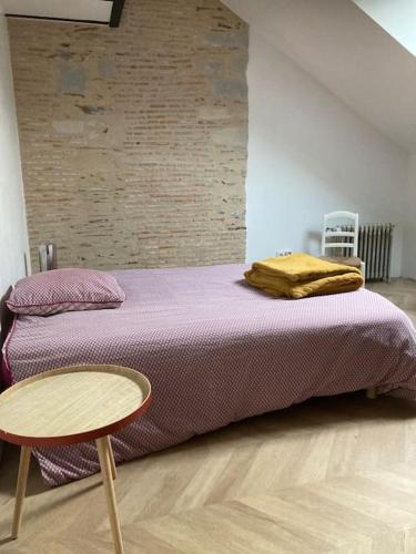 - une chambre avec un lit violet et une table dans l'établissement Atypique Chevreul, à Angers