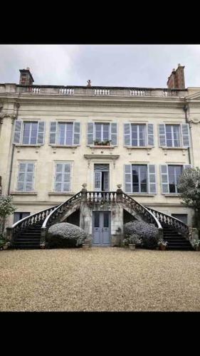 un grand bâtiment blanc avec un escalier devant dans l'établissement Atypique Chevreul, à Angers