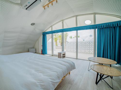 宮古島にあるGLAMTECH RESORTS HEAVENのベッドルーム(大型ベッド1台、テーブル付)