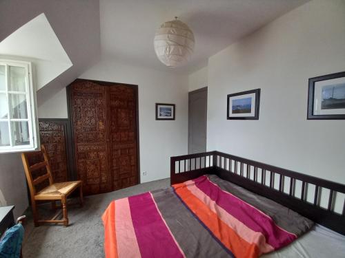 a bedroom with a bed and a wooden door at Maison de vacances à la plage in Saint-Nic