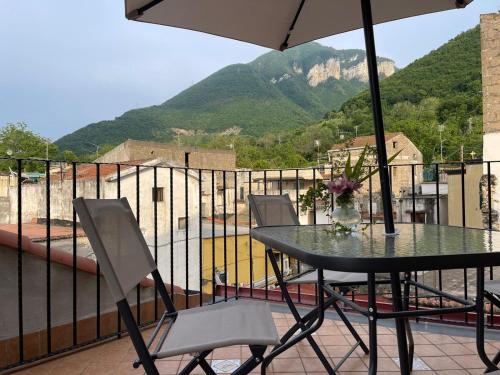 a table with chairs and an umbrella on a balcony at B&B Ai Cortili in Sant'Egidio del Monte Albino