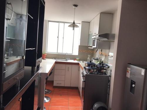 利馬的住宿－Hermoso Duplex en Chorrillos，厨房配有水槽和炉灶 顶部烤箱