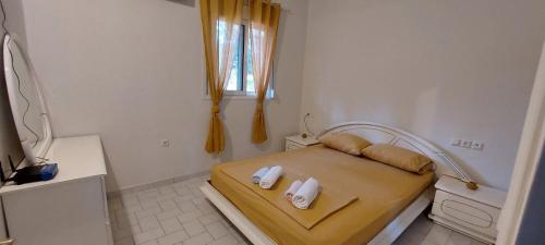 um pequeno quarto com uma cama e uma janela em Villa Laguna -house by the beach em Karavómilos
