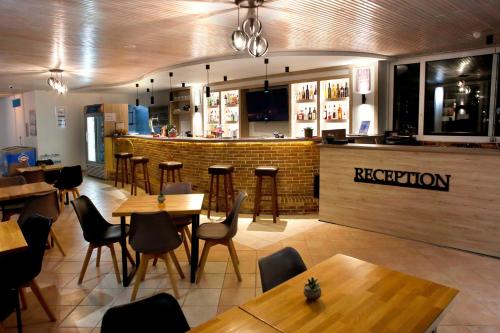 a restaurant with wooden tables and chairs and a bar at Akis Studios Alykes in Alykes