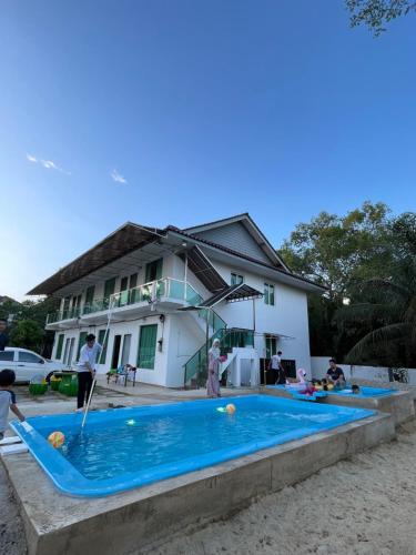 una piscina frente a una casa en Akram Homestay en Kota Bharu