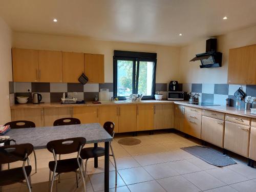 a kitchen with wooden cabinets and a table and chairs at Résidence de la gare, chambre meublée in Longjumeau