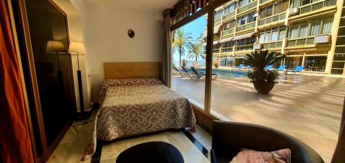 a bedroom with a bed and a view of a pool at Primera línea de playa in Marbella