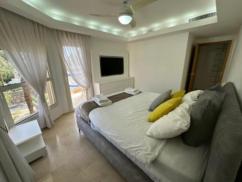 a bedroom with a large bed and a television at YalaRent Amdar Lux in Eilat