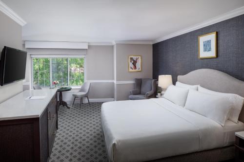 een hotelkamer met een groot bed en een bureau bij The Madison Hotel in Morristown