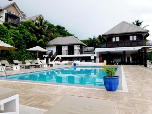 uma grande piscina com uma casa ao fundo em The Crow's Nest Resort Fiji em Korotogo