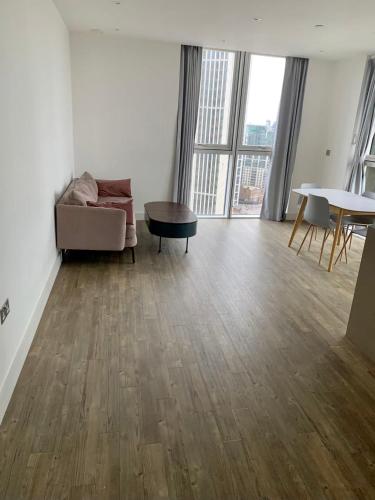 a living room with a couch and a table at Spacious & Cozy One Bedroom Flat in Dagenham