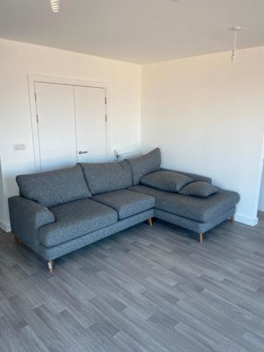 uma sala de estar com dois sofás azuis num quarto em Spacious & Cozy One Bedroom Flat em Dagenham