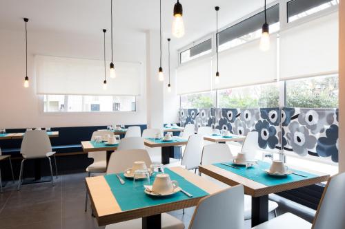 a dining room with tables and chairs and windows at La Regence in Courbevoie