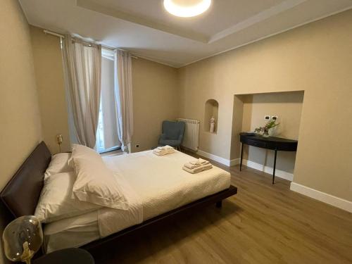 a bedroom with a bed with a desk and a window at B&B Ai Cortili in Sant'Egidio del Monte Albino