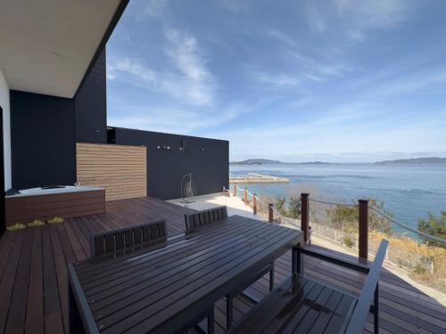 a house with a deck with a view of the water at SETO CLAS AJI THE SEASIDE HILLS RESORT in Aji
