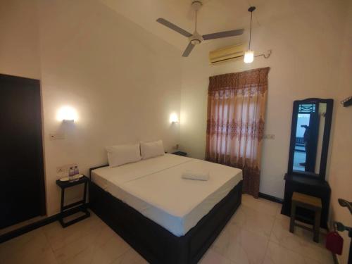una camera con letto e ventilatore a soffitto di Atteriya CHILL ad Arugam