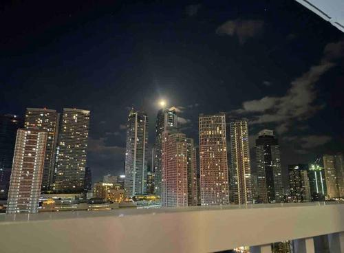 a view of a city skyline at night at Beautiful 1BR balcony w/65UHDTV Wifi Netflix, pool in Manila