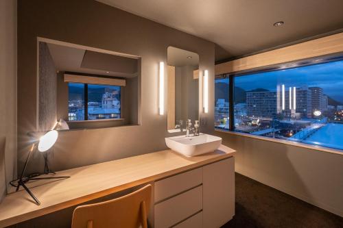 a bathroom with a sink and a window with a view at Onn Yuda Onsen in Yamaguchi