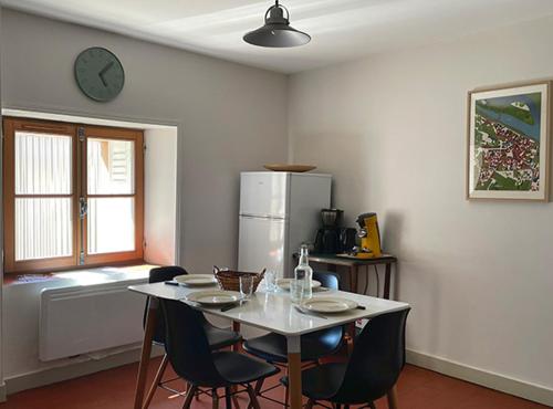 une cuisine avec une table avec des chaises et un réfrigérateur dans l'établissement Les Gites Saint Aignan - Proche du Zoo de Beauval, à Saint-Aignan