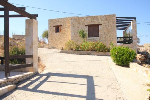 a stone house with a shadow on the ground at Gavdos Princess in Gavdos