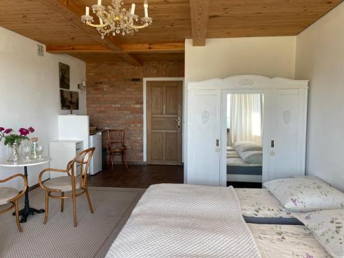 a bedroom with two beds and a table and a dining room at Cisowe Sioło in Jeleniewo