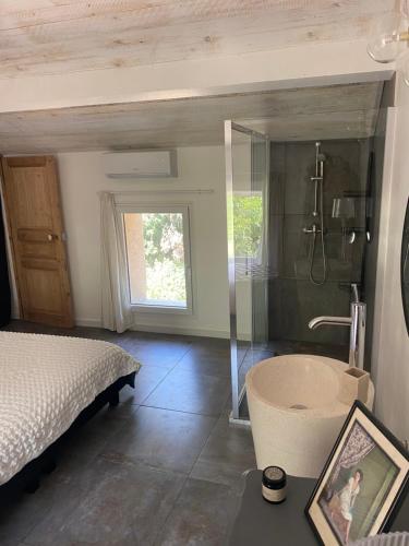 - une chambre avec un lit, une douche et une baignoire dans l'établissement Mas des garrigues, à Bouchet