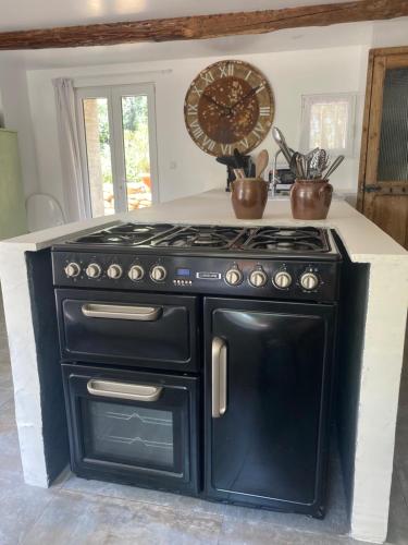 La cuisine est équipée d'un four avec plaques de cuisson noires. dans l'établissement Mas des garrigues, à Bouchet