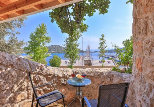 a patio with a table and chairs on a stone wall at Jasmine Otel in Kas