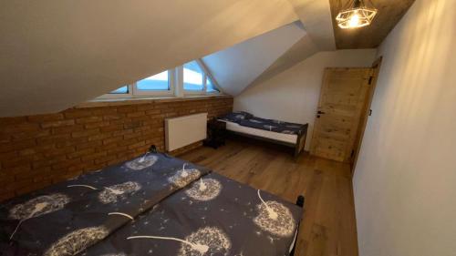 an attic room with a bed and a window at Apartmany FABRIK in Vysoká nad Kysucou