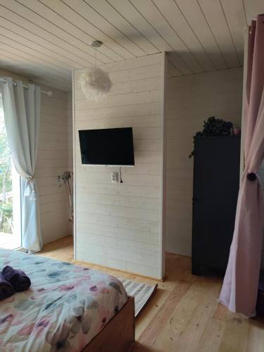 a bedroom with a bed and a flat screen tv at OFILDLEAU in Sillans-la Cascade