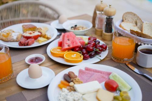 a table with plates of breakfast foods and drinks at Hotel Club-E in Fethiye