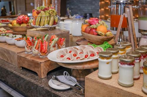 a buffet with plates of food and bowls of fruit at Regenta Dehradun by Royal Orchid Hotels Limited in Dehradun