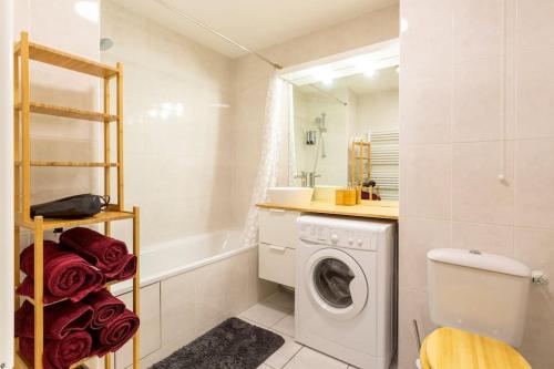 łazienka z pralką, pralką i suszarką w obiekcie Cosy appart entre Paris et Disneyland w mieście Villiers-sur-Marne