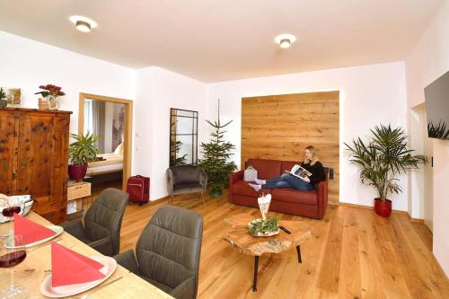 a woman sitting on a couch in a living room at Ferienwohnung im Markt Irdning in Altirdning