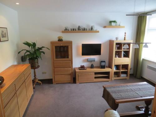 ein Wohnzimmer mit einem TV und einem Holzschrank in der Unterkunft Ferienwohnung Dörner in Pirna