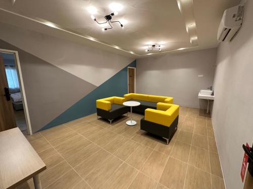 A1 Hotel Sungai Petani في سونغاي بيتاني: غرفة انتظار وكراسي صفراء وسوداء وطاولة