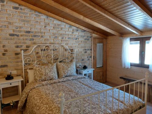 - une chambre avec un lit et un mur en briques dans l'établissement CON ENCANTO, à Cabezuela del Valle