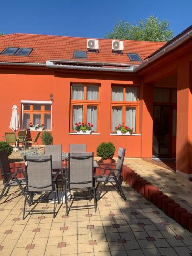 a patio with chairs and a table in front of a house at Szent István Wellness Panzió in Makó