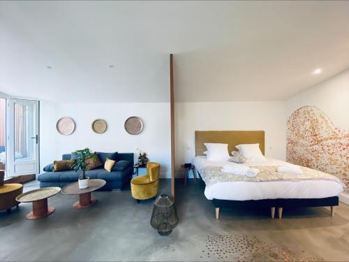 a bedroom with a bed and a blue couch at La King Le 50 Suites and SPA in Bordeaux