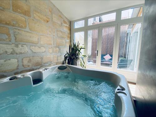 a large bath tub in a room with a window at La King Le 50 Suites and SPA in Bordeaux