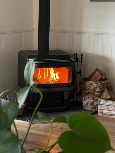 a black stove with a fire in a room at Bluegums Cabins Barrington Tops in Bandon Grove