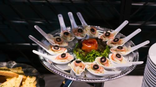 a platter of sushi on a plate with tongs at Silverland Jolie Hotel in Ho Chi Minh City