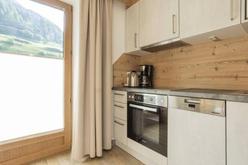 a kitchen with a stove top oven next to a window at Landhaus Fiegl in Sölden