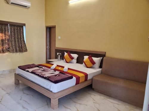 PurbbadulkiにあるSundarban Tiger Roar Resortのベッドルーム(ベッド1台、ソファ付)