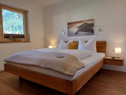 een groot bed in een slaapkamer met een raam bij Apart Anna in Mayrhofen